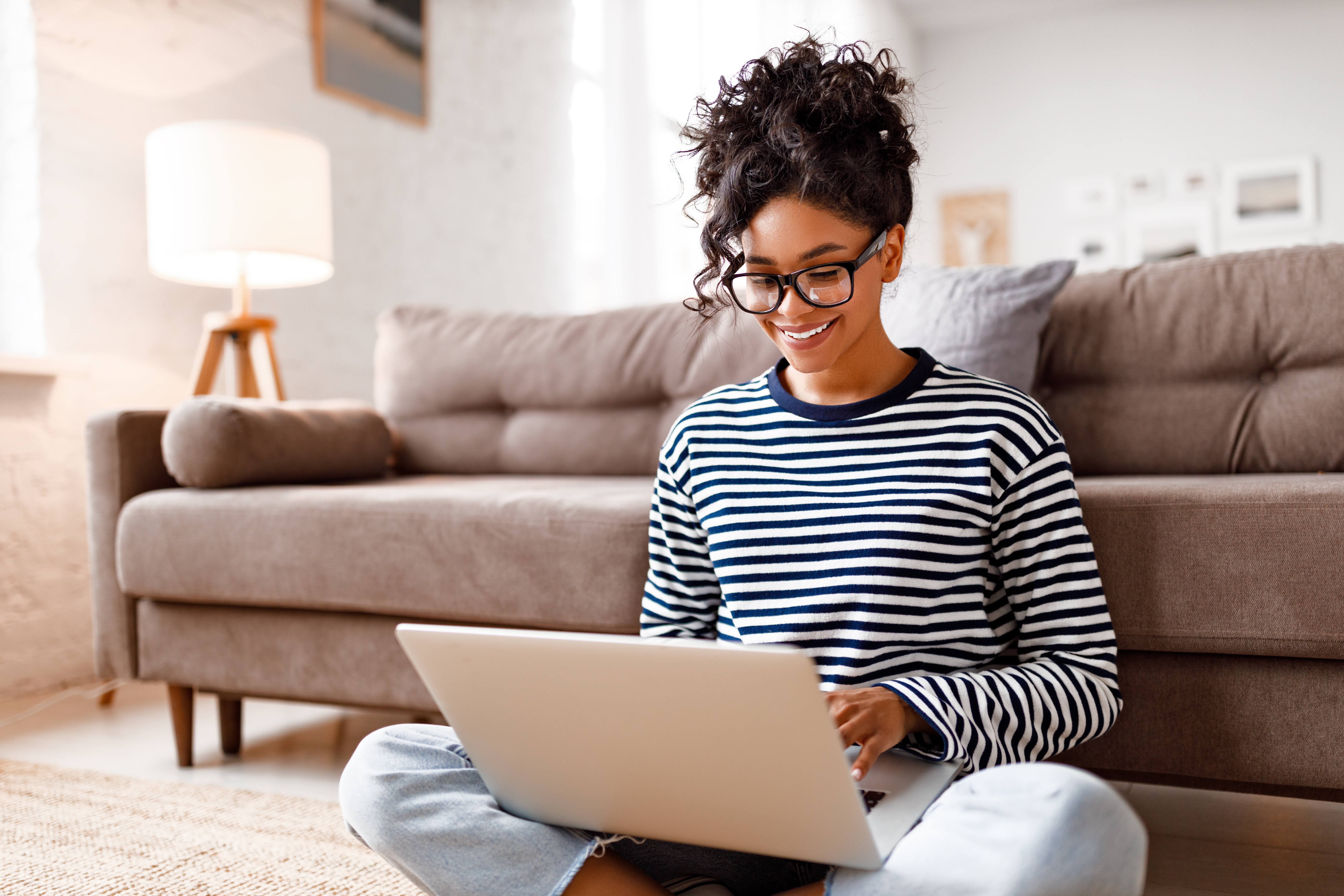 Joyful relaxed ethnic woman using laptop with interest at home Joyful relaxed ethnic woman using laptop with interest at home